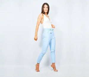 Woman wearing white top and light blue pants.